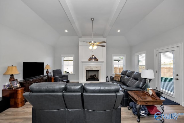 living room with a wealth of natural light, ceiling fan, lofted ceiling with beams, and light hardwood / wood-style floors