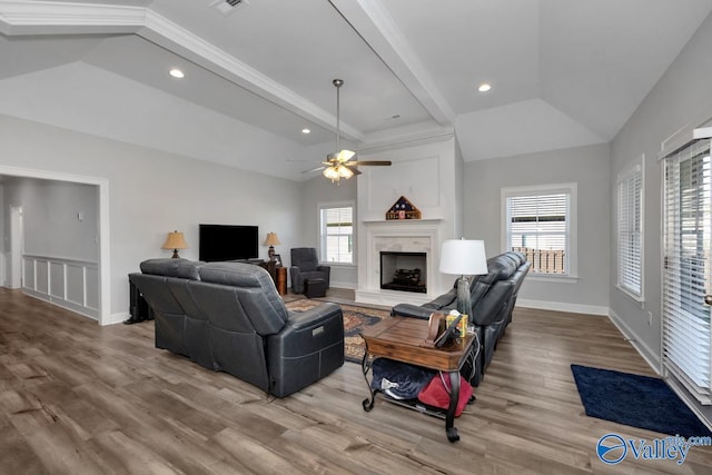 living room featuring hardwood / wood-style floors, a high end fireplace, and a healthy amount of sunlight