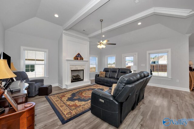 living room featuring ceiling fan, light hardwood / wood-style flooring, vaulted ceiling, and ornamental molding