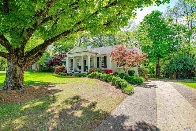 neoclassical / greek revival house featuring a front lawn