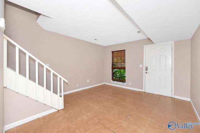 foyer with stairs, light tile patterned floors, and baseboards