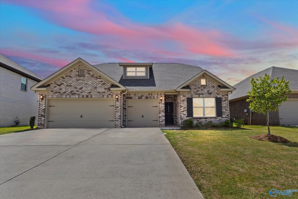 craftsman inspired home featuring a garage and a lawn