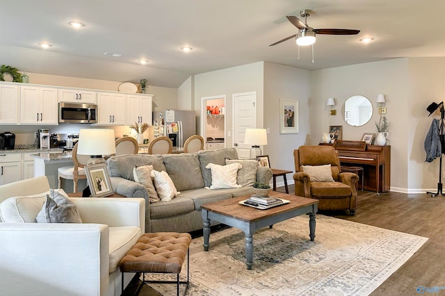 living room featuring ceiling fan and dark hardwood / wood-style floors