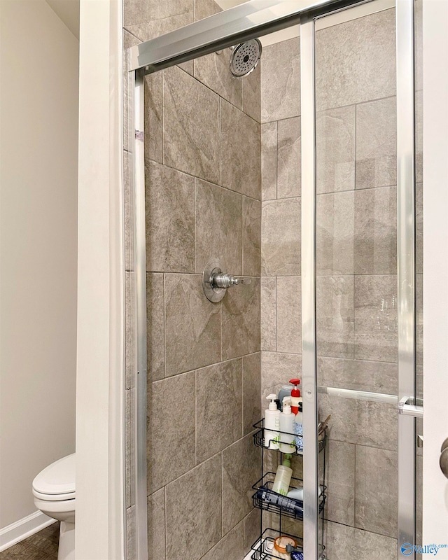 bathroom featuring toilet and an enclosed shower