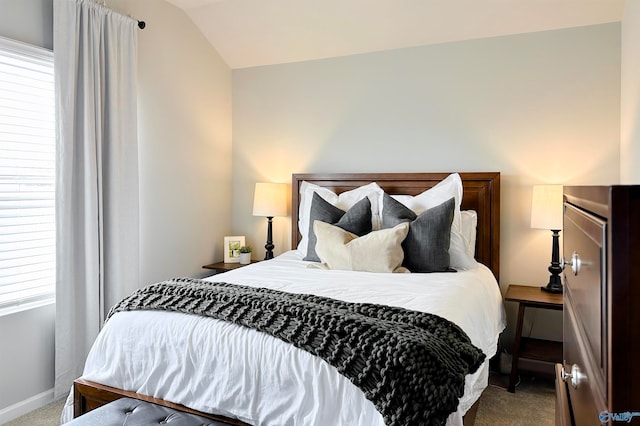 carpeted bedroom with lofted ceiling and multiple windows