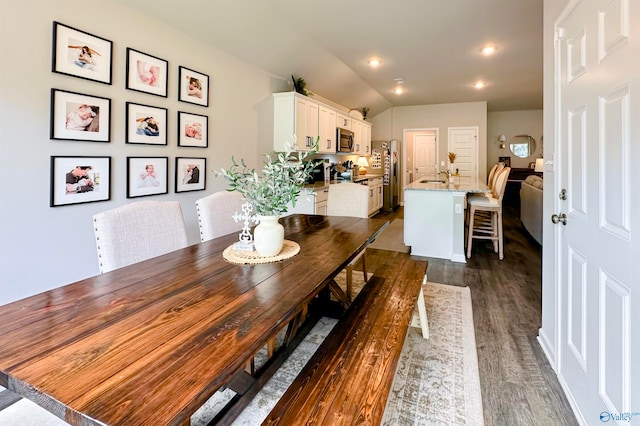 dining area with lofted ceiling, dark hardwood / wood-style flooring, and sink