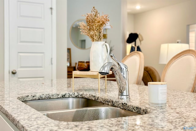 interior details featuring light stone countertops and sink