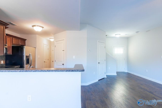 kitchen with kitchen peninsula, stainless steel fridge with ice dispenser, decorative backsplash, and dark wood-type flooring