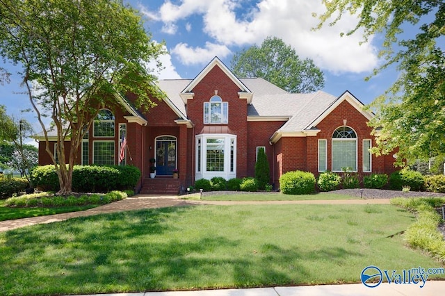 view of front facade featuring brick siding and a front lawn