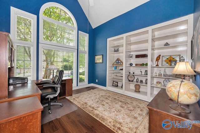 office space with baseboards, wood finished floors, a wealth of natural light, and high vaulted ceiling