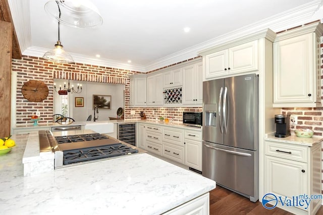 kitchen with an inviting chandelier, a sink, beverage cooler, stainless steel appliances, and ornamental molding