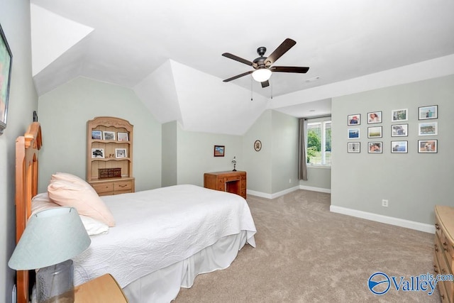 bedroom featuring baseboards, a ceiling fan, vaulted ceiling, and light colored carpet