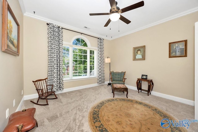 living area with crown molding, baseboards, ceiling fan, and carpet