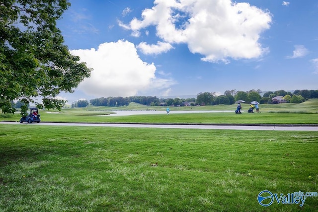 surrounding community with a lawn and a water view