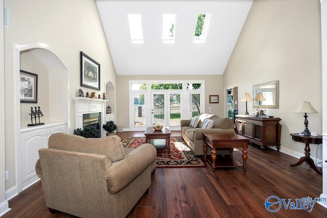 living room featuring a glass covered fireplace, high vaulted ceiling, baseboards, and dark wood finished floors