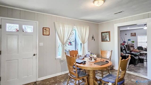 dining room with crown molding, a healthy amount of sunlight, visible vents, and baseboards