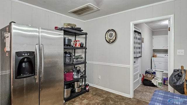 kitchen featuring a decorative wall, visible vents, stainless steel fridge, and ornamental molding