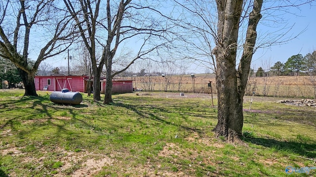 view of yard with a rural view and an outdoor structure