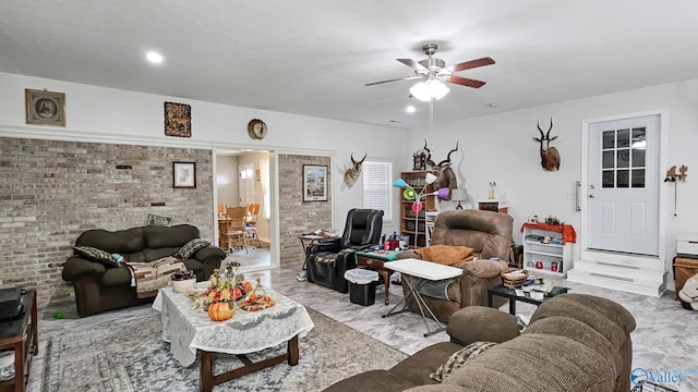 living area featuring marble finish floor, brick wall, and a ceiling fan