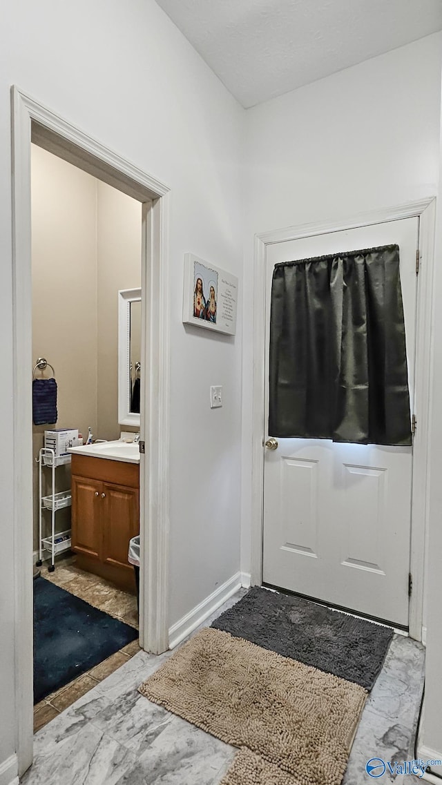 interior space featuring baseboards and marble finish floor