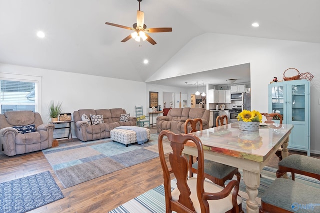 dining space featuring high vaulted ceiling, ceiling fan, and light hardwood / wood-style floors