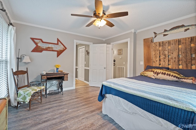 bedroom featuring ceiling fan, a textured ceiling, crown molding, and wood-type flooring