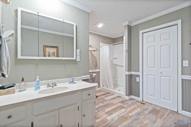 bathroom featuring vanity, ornamental molding, a textured ceiling, hardwood / wood-style floors, and a shower with shower curtain