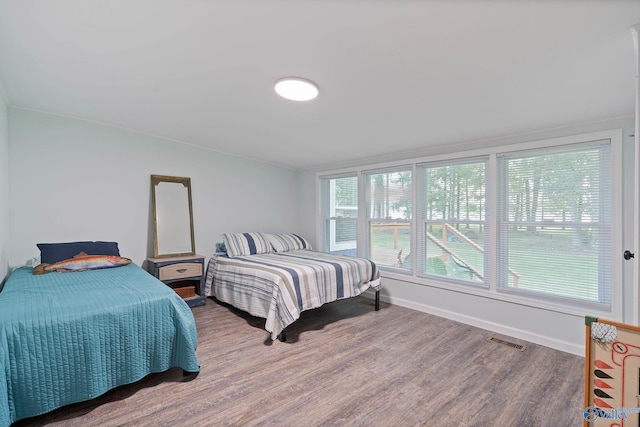 bedroom featuring lofted ceiling, ornamental molding, and hardwood / wood-style flooring