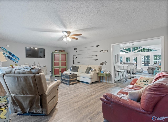 living room with ceiling fan, hardwood / wood-style floors, and a textured ceiling