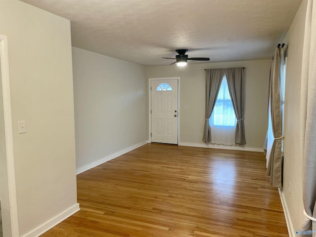 entryway with ceiling fan, a textured ceiling, and light hardwood / wood-style floors