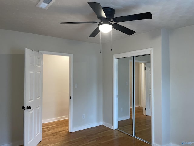 unfurnished bedroom featuring hardwood / wood-style flooring, ceiling fan, and a closet