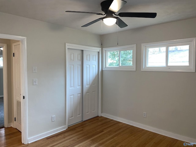 unfurnished bedroom featuring hardwood / wood-style flooring, ceiling fan, and a closet