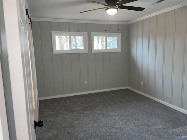 carpeted empty room with crown molding, a barn door, and ceiling fan