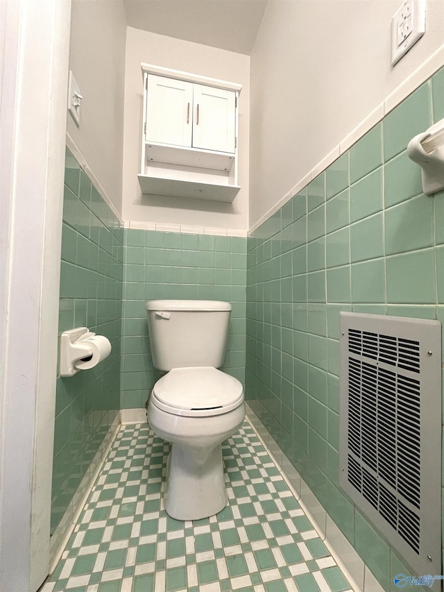 bathroom with tile walls and toilet