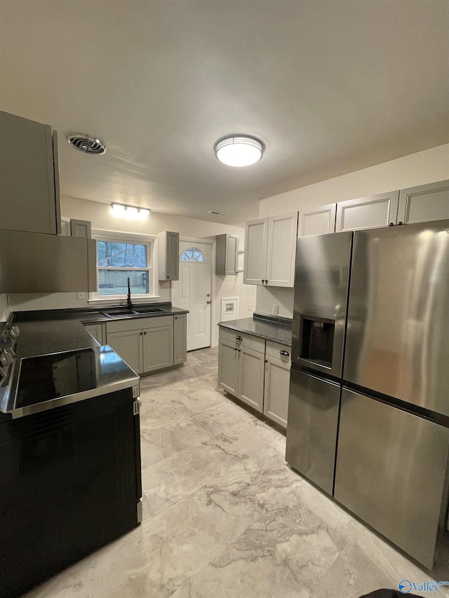 kitchen featuring gray cabinetry, sink, electric range, and stainless steel fridge