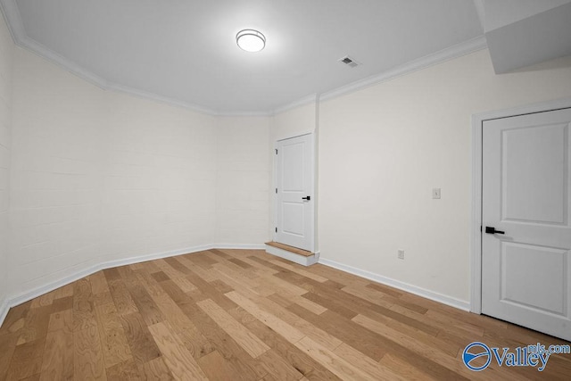 empty room featuring light hardwood / wood-style floors and ornamental molding