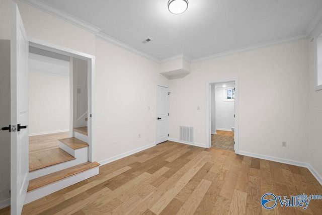 empty room featuring crown molding and light hardwood / wood-style flooring