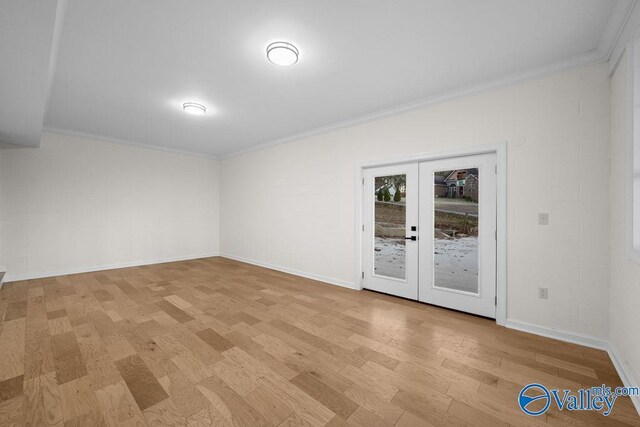 spare room featuring french doors, light hardwood / wood-style floors, and ornamental molding