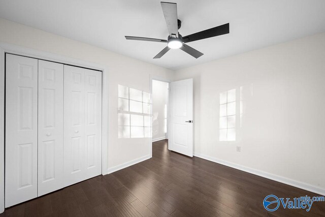 unfurnished bedroom featuring a closet, dark hardwood / wood-style floors, and ceiling fan