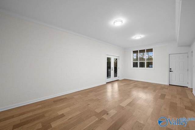 spare room featuring light hardwood / wood-style floors, ornamental molding, and french doors