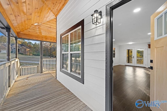 wooden deck with a porch and french doors