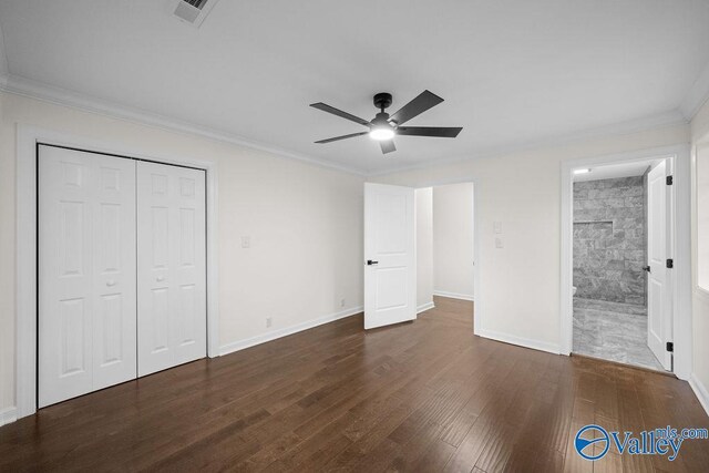 unfurnished bedroom with ceiling fan, crown molding, dark wood-type flooring, tile walls, and a closet