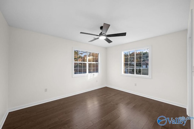 empty room with dark hardwood / wood-style floors, a wealth of natural light, and ceiling fan