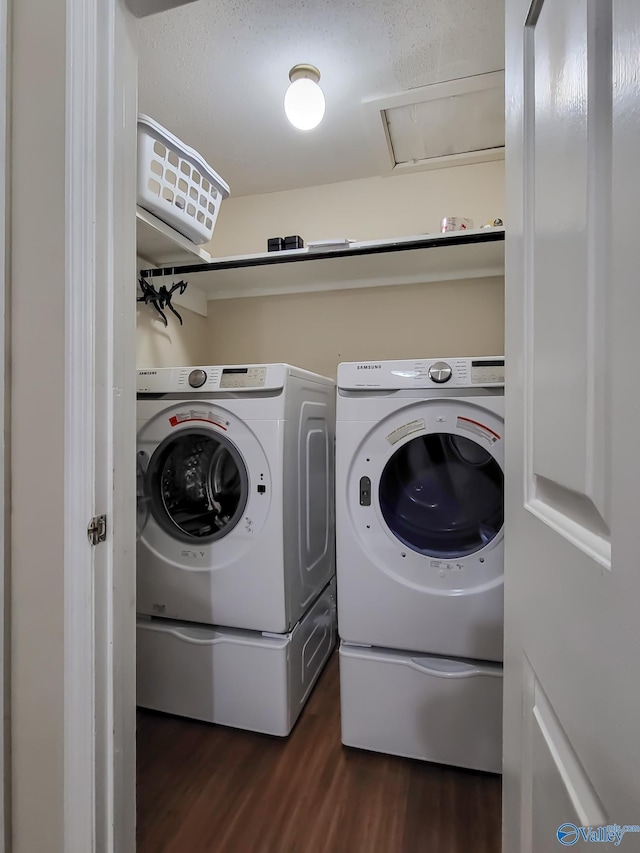 washroom with dark wood-type flooring and washer and clothes dryer