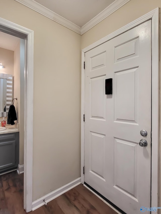 entryway featuring dark wood-type flooring, sink, and crown molding