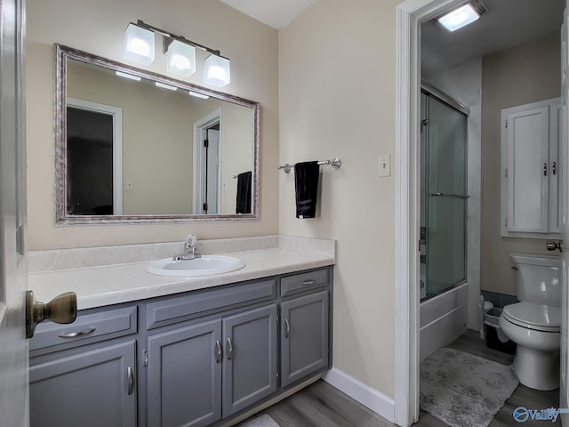 full bathroom featuring shower / bath combination with glass door, vanity, and toilet