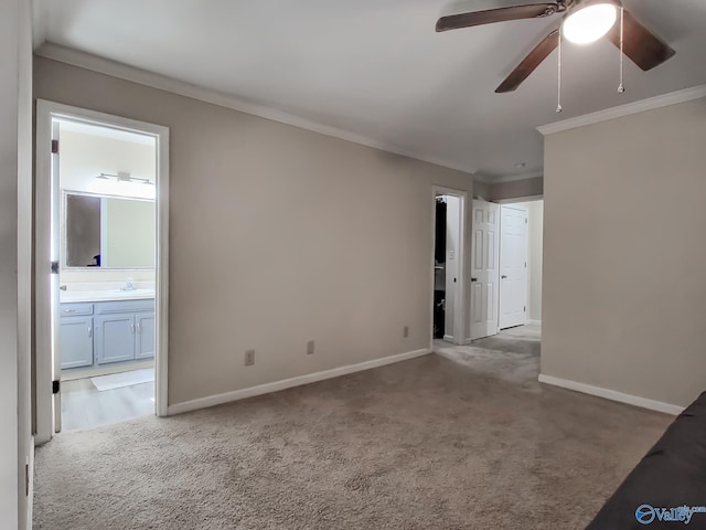 carpeted spare room with ceiling fan, sink, and ornamental molding