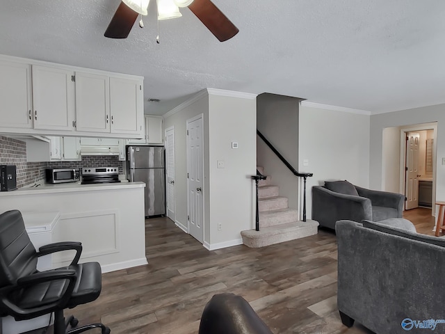 kitchen featuring white cabinets, stainless steel appliances, backsplash, dark hardwood / wood-style floors, and ornamental molding