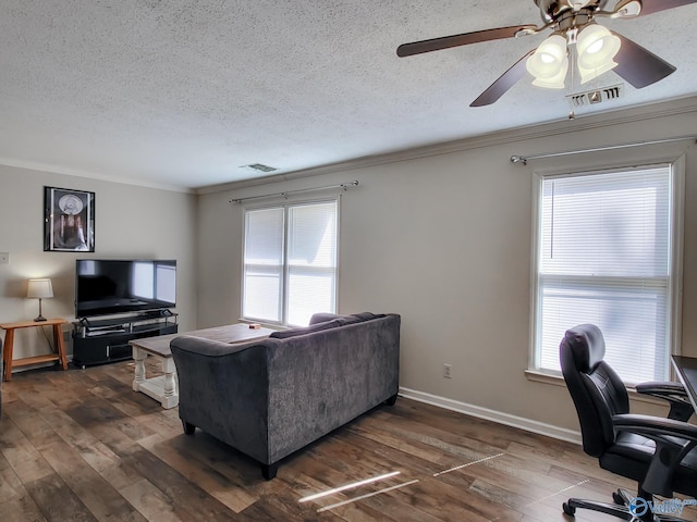 living room featuring a textured ceiling, dark hardwood / wood-style flooring, and ornamental molding