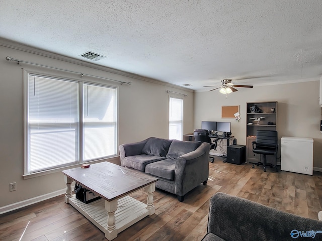 living room featuring crown molding, a textured ceiling, and wood-type flooring